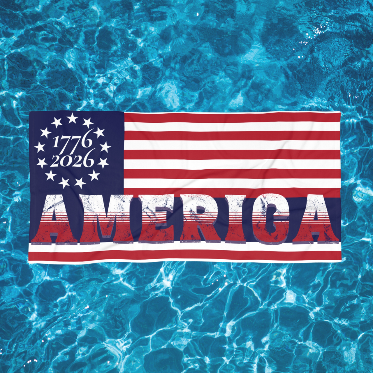 patriotic towel with '1776 - 2026 AMERICA' text on a blue water background