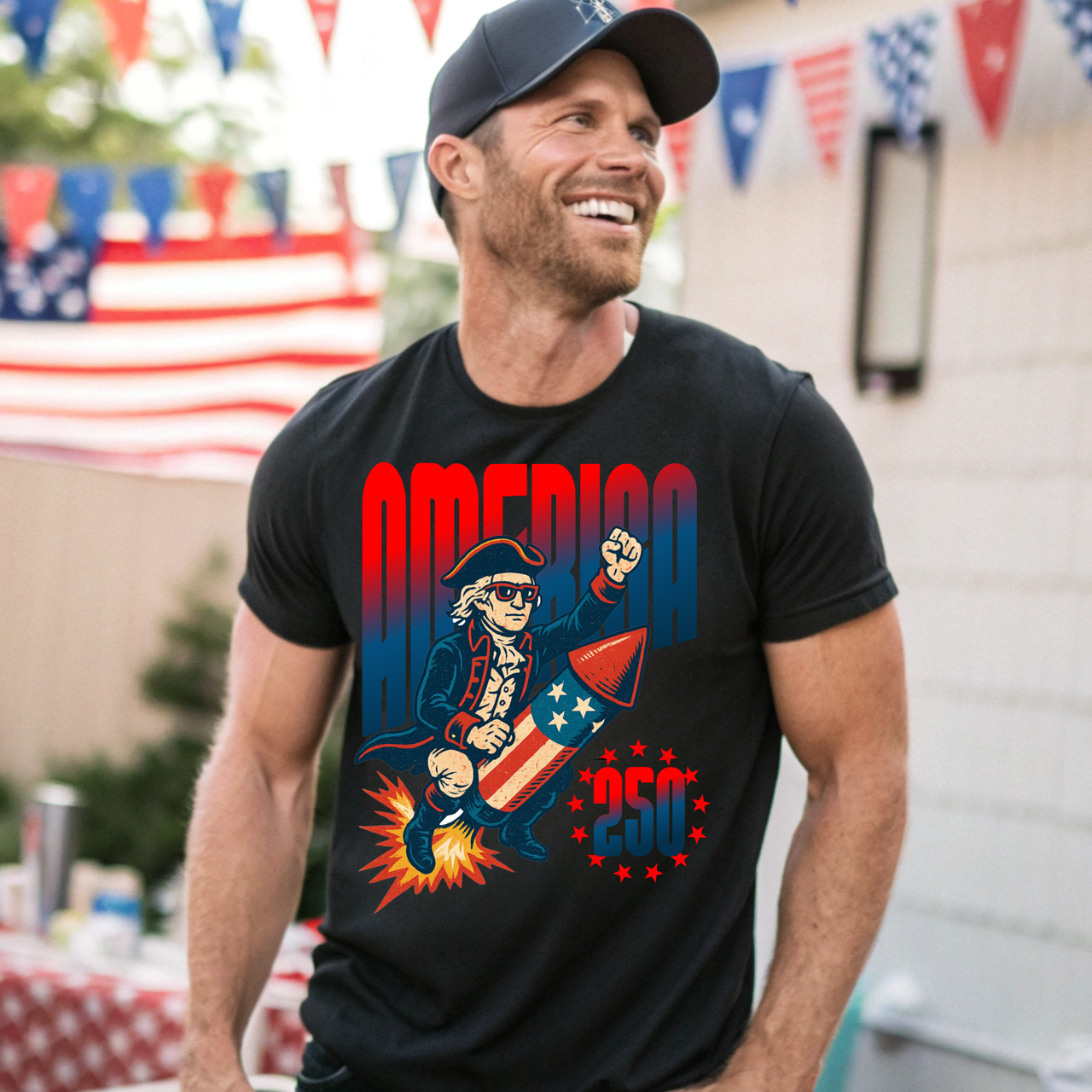 Man wearing a black t-shirt with a patriotic America 250 design, standing outdoors with American flags in the background.