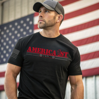 A patriotic man wearing our black t-shirt with 'AMERICA 1ST'  in front of an American flag.