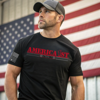 A patriotic man wearing our black t-shirt with 'AMERICA 1ST'  in front of an American flag.