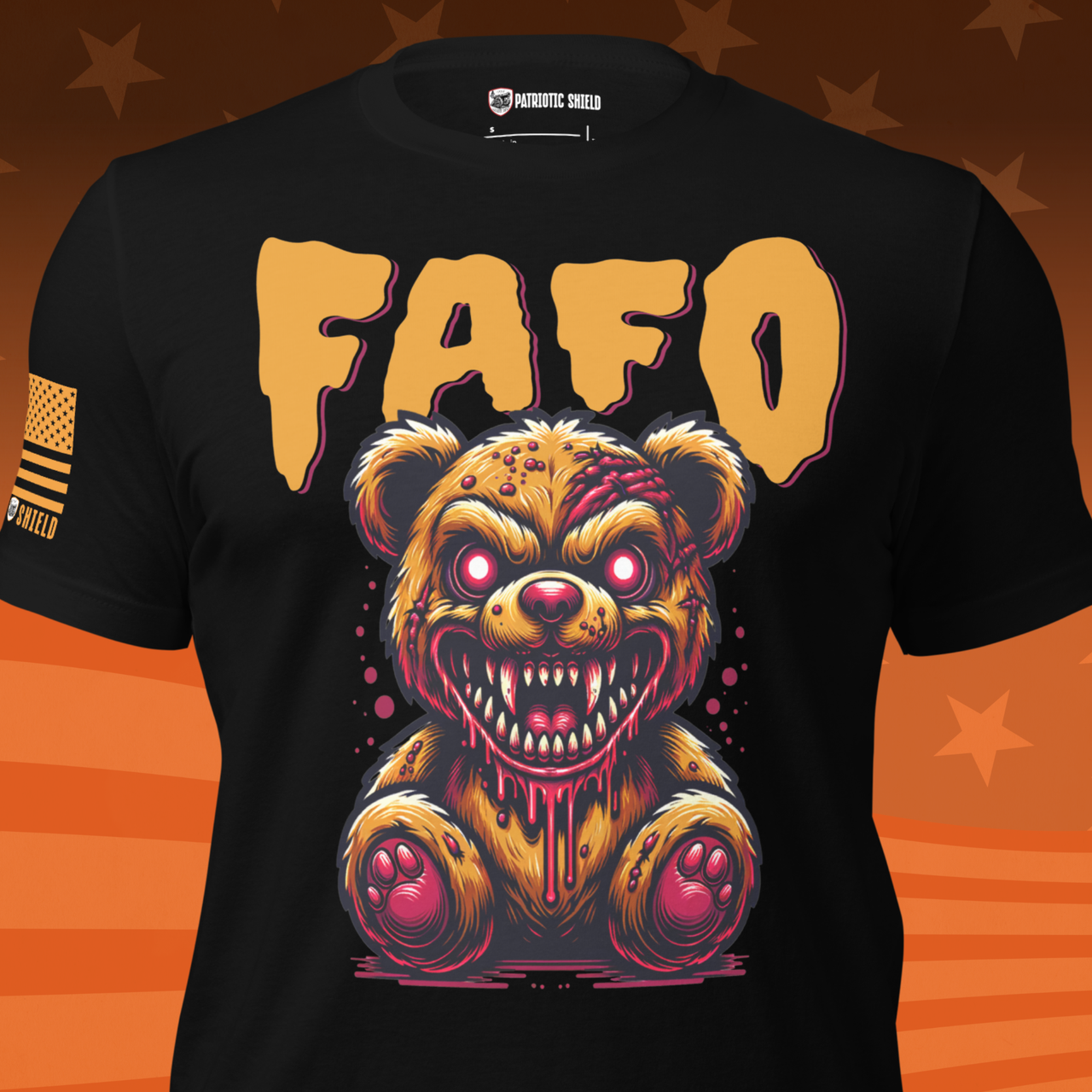 A black patriotic halloween short-sleeve graphic t-shirt featuring a creepy, dripping monster teddy bear with glowing red eyes and a large 'FAFO' text print above it. The shirt is displayed on a stylized orange background with star patterns.