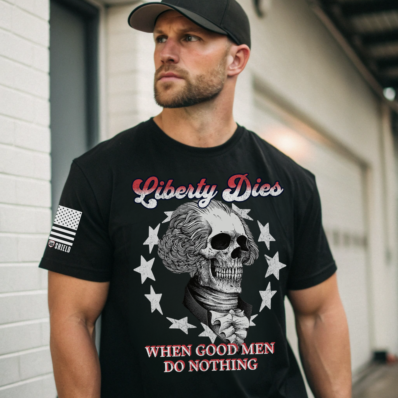 Man wearing a black t-shirt with a patriotic graphic design that says liberty dies when good men do nothing.